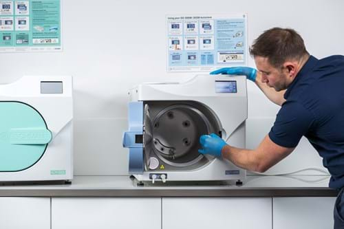 Man in a navy blue shirt servicing an autoclave